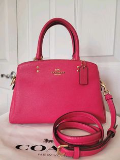 Brand New with Tags! COACH Mini Lillie Carryall Satchel in Bold Pink Crossgrain leather Center zip compartment Snap closure, fabric lining Handles with 4 1/4" drop Outside open pocket Detatchable strap with 21 1/2" drop for crossbody or Shoulder wear 4 protective feet on base 10 1/4" L X 6 3/4" H X 4 1/4" D Gold-tone Hardware Chloe Bags Handbags, Potli Bag, Chloe Bags, Leather Sling Bag, Potli Bags, Base 10, Leather Baby, Leather Coach, Leather Mini