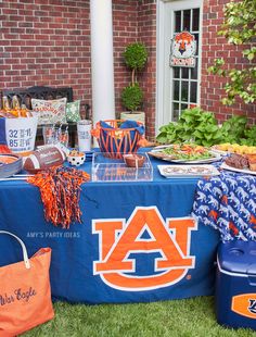 an auburn football party with food and decorations on the table, along with coolers