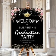 a black and white graduation party welcome sign with pink flowers on the front, in an ornate room