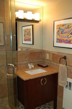 a bathroom with a sink, mirror and shower stall