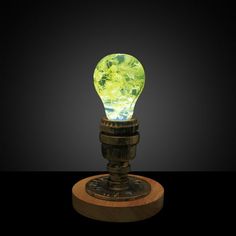 a green light bulb sitting on top of a wooden stand