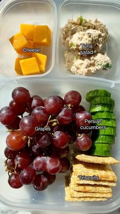 a plastic container filled with grapes, crackers and cheese