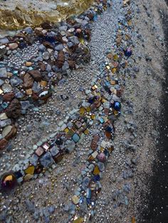 there are many different colored rocks on the beach