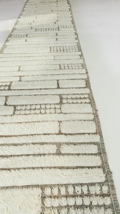 a long white rug on the floor with lines drawn across it in different colors and sizes