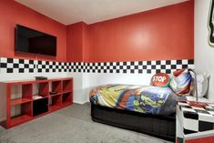 a bedroom with red walls and black and white checkered decor