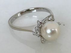 Here is a stunning 14k white gold ring set with 7mm pearl and surrounded by six round diamonds. A great ring that will get many compliments! Metal: 14K White Gold Stone: 7mm pearl, 6 round single cut diamonds Finger Size: 5.5 (please contact us if you need another size) Weight: 2.8 grams SKU# 21SB031618 If you have any questions on this item, please message us! GandDJewelers.etsy.com Please note that all of our pieces have been analyzed & identified by a Gemological Institute of America Cert Elegant Silver Pearl Ring With Center Stone, Formal Round Cut Solitaire Pearl Ring, Classic Silver Ring With Akoya Pearl, Elegant Silver Platinum Pearl Ring, Formal White Gold Ring With Pearl Drop, Formal White Gold Solitaire Pearl Ring, Classic Silver Pearl Ring In Platinum, Classic Silver Platinum Pearl Ring, Elegant Silver Pearl Ring With Prong Setting