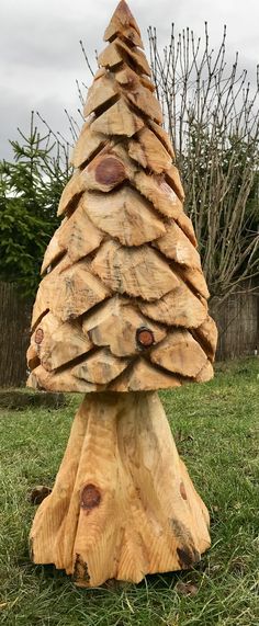 a wooden christmas tree sitting on top of a lush green field