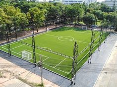 an aerial view of a soccer field in the middle of a park with lots of trees