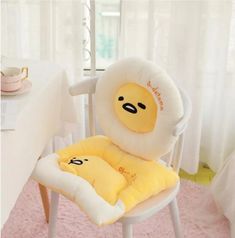 a chair with a pillow shaped like a stuffed animal on it's back in front of a dining room table