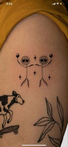 a woman's arm with a cow and skateboard tattoo on her left side