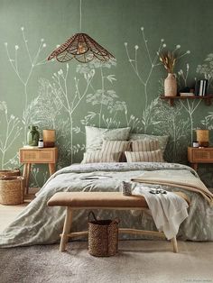 a bedroom with green walls and white flowers on the wall