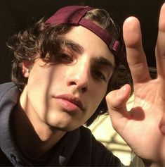 a young man making the v sign with his hand and wearing a headband on