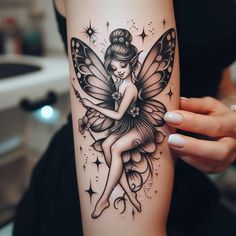 a woman's arm with a black and white tattoo design on it, featuring a fairy