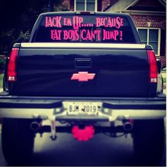 the back end of a pickup truck with pink lettering on it