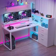 a computer desk with two monitors and a keyboard in front of the monitor is lit up by neon lights