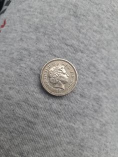 a coin sitting on top of a gray shirt