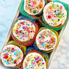 a tray filled with cake covered in frosting and sprinkles