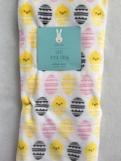 a baby blanket with yellow and pink polka dots on it, next to a tag