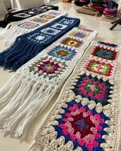 crocheted scarves are lined up on the table