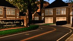 a large sign is in front of some brick houses and trees on the side of the road