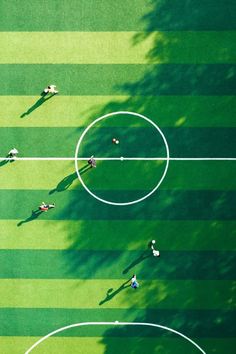 an overhead view of a soccer field with the ball in the middle and players on it