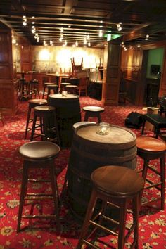 several stools and tables in a room with red carpet