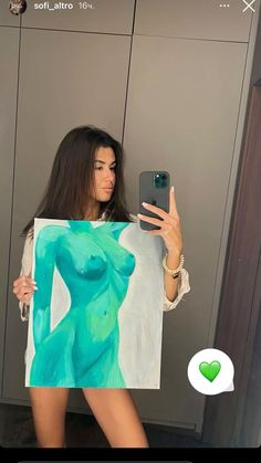 a woman taking a selfie in front of a mirror with her cell phone and painting