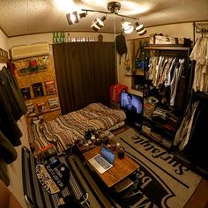 a bedroom with a bed, desk and television in it