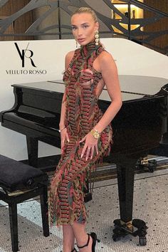 a woman standing in front of a piano