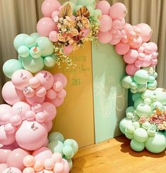 there are balloons and flowers in the shape of archs on the table next to each other