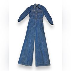 Make A Statement With This 1970s Rafael Denim Bell Bottom Jumpsuit. Embrace Your Inner Hippie And Channel Your Unique Style With This Chic Piece. Perfect For Any Occasion! Era: 1970s Style: Jumpsuit Tag Size: Undetermined Color: Denim Rating: 8 10; Flawed Please Pictures Content: Denim Measurements: Bust: 36” Drop: 8.5” Waist: 25” Inseam: 30.5” Length: 68” Shoulder: 13” Inner Sleeve: 16” Outer Sleeve: 28@ Cleaning + Care: Vintage Denim Jumpsuit For Work, Vintage Jumpsuits And Rompers For Fall, Vintage Medium Wash Denim Jumpsuit For Work, Vintage Denim Overall Jumpsuit For Fall, Fitted Blue Denim Retro Jumpsuit, Vintage Denim Overall Jumpsuit For Work, Vintage Denim Workwear Jumpsuit, Vintage Fitted Denim Jumpsuit Overall, Vintage Fitted Denim Jumpsuit For Work