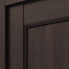 a close up view of the wood grained finish on this cabinet door, which is dark brown