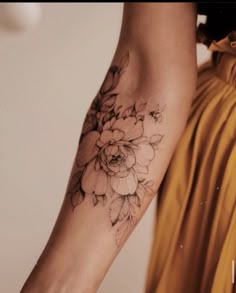 a woman's arm with a flower tattoo on the left side of her arm