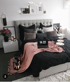 a black and white bedroom with candles on the nightstands, bedding and pillows