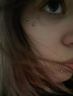 a woman with piercings on her nose looking at the camera