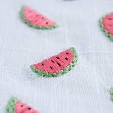 several pieces of crocheted watermelon on a white tablecloth with green trim