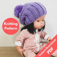 a doll sitting on the floor wearing a knitted hat