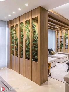 a living room filled with lots of furniture next to a wall covered in greenery