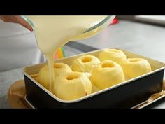 someone pouring sauce on some food in a pan