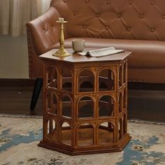 a wooden table with a cup on it in front of a couch