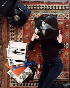 a woman laying on top of a rug covered in books