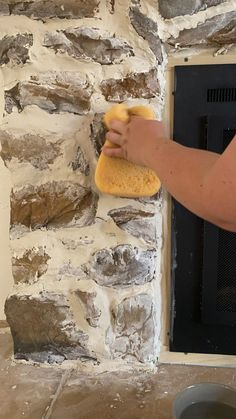 a person is wiping up the wall with a sponge