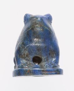 a blue ceramic animal figurine on a white surface with a hole in the middle