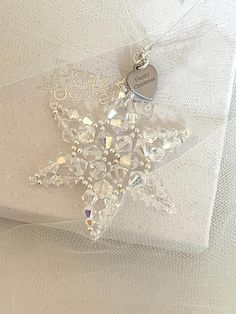 a star ornament on a white cloth with a heart hanging from it's side