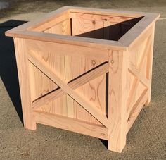 a wooden planter sitting on top of a cement ground