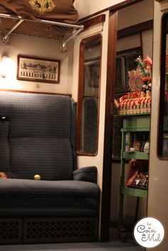 the inside of a train car with blue couches and other items on shelves in it