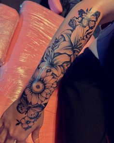 a woman's arm with flowers and butterflies on it