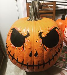 two pumpkins that have been painted to look like jack - o'- lanterns