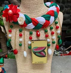 a close up of a mannequin wearing a necklace with watermelon and pearls