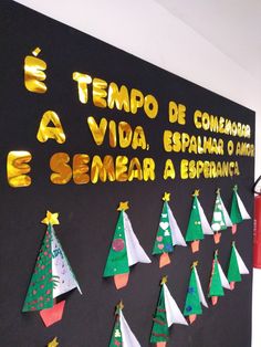 a bulletin board decorated with christmas trees and gold foil lettering that reads, tempo de conear e sema